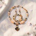 Peach Blossom Jewelry Set with cloisonne enamel heart pendant, peach barrel beads and amber crystals, photographed with cherry blossoms on linen
