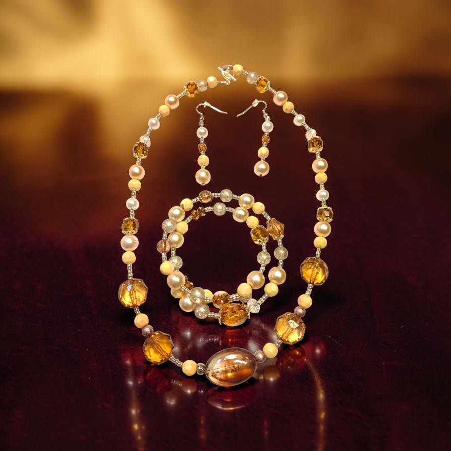 Amber Cat Eye Jewelry Set displayed on dark surface with warm golden backdrop, featuring cat's eye beads, faceted amber crystals and freshwater pearls