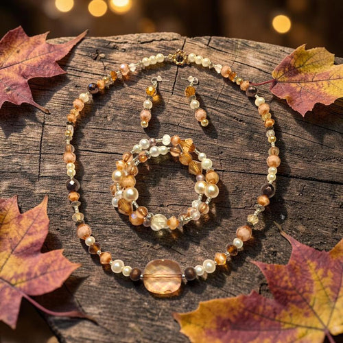 Autumn Amber Jewelry Set displayed on rustic wood with fall maple leaves and golden bokeh lights, featuring amber crystals, smoky quartz, and cream pearls