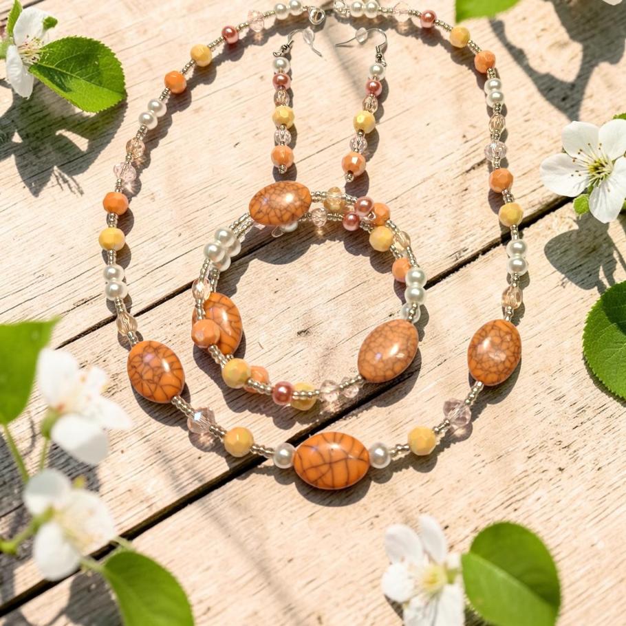 Crackling Rose Jewelry Set displayed on whitewashed wood with spring blossoms, featuring orange crackle agate ovals, yellow jade, blush pearls and clear crystals