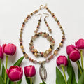 Tulip Garden Jewelry Set with blush and bronze pearls, champagne crystals and silver double-oval pendant, photographed with magenta tulips