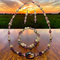 Lavender Cat's Eye Jewelry Set with purple crystals, white pearls and hematite cat's eye focal bead, photographed against a sunset sky