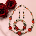 Red Rose Romance Jewelry Set with large faceted red crystal beads, white pearls, black onyx and carnelian chips, photographed with deep red roses