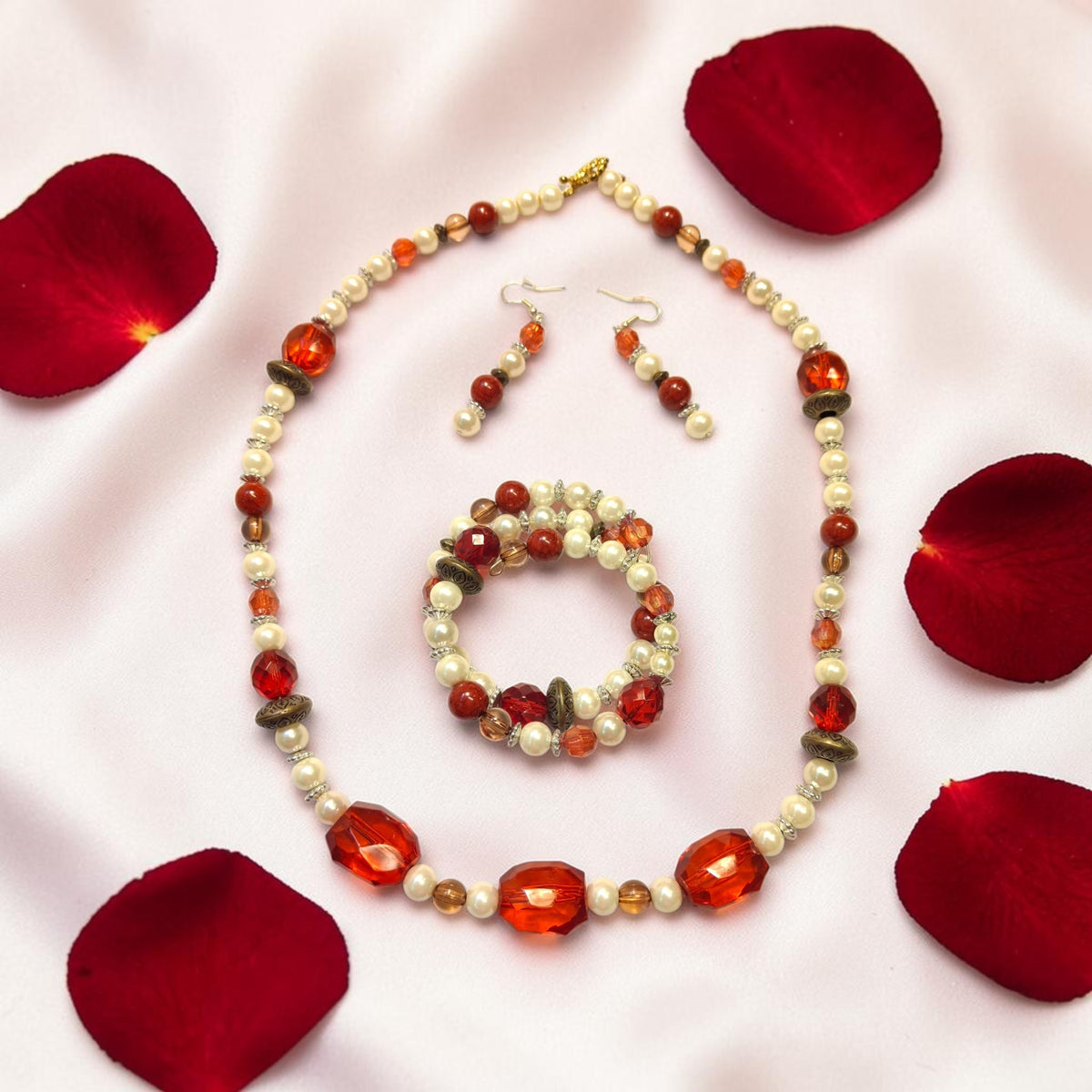 Touch of Romance beaded jewelry set with red crystals, cream pearls and bronze accents on white silk with rose petals
